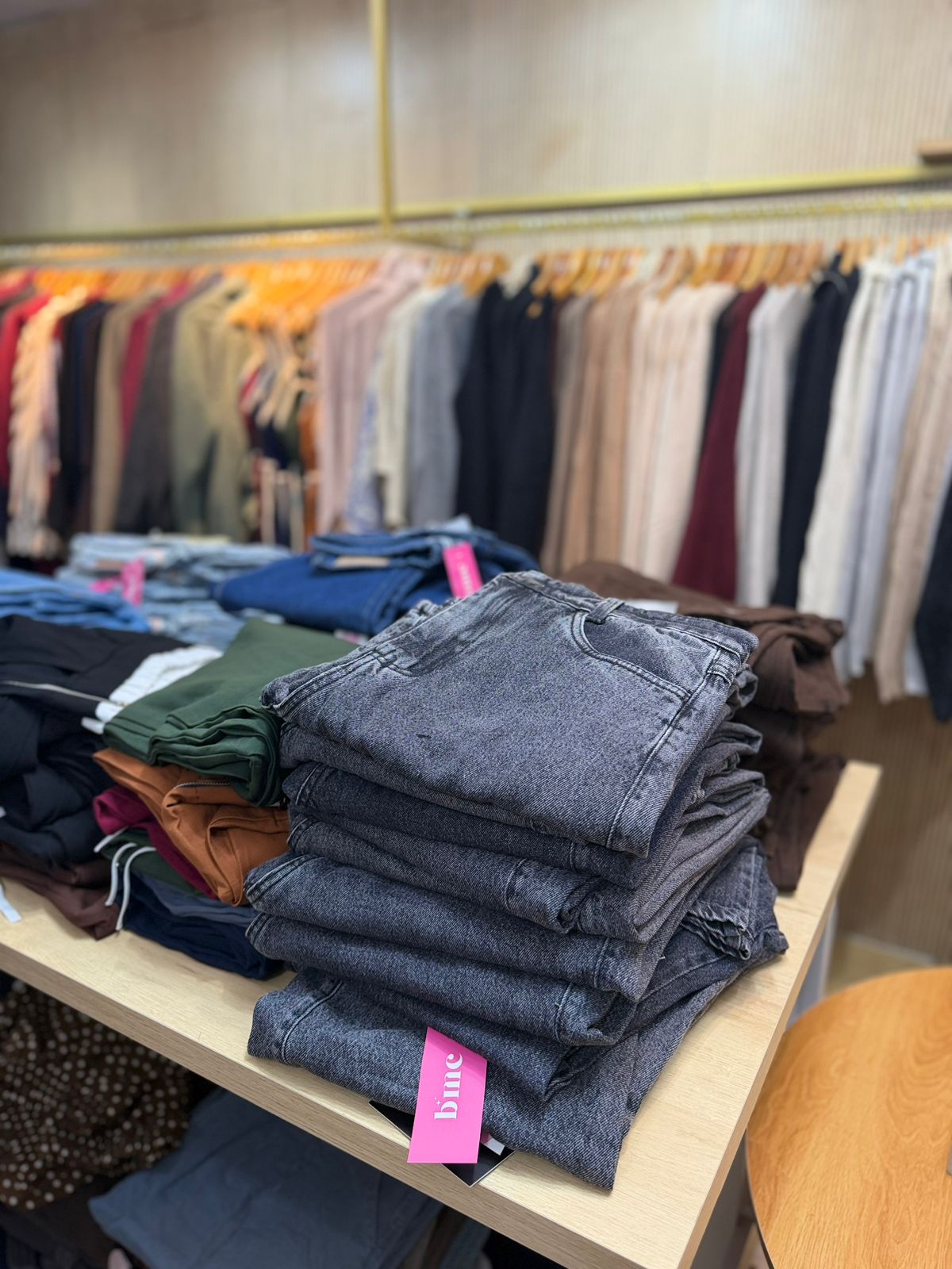 Jeans dobrados em pilha sobre a mesa central da loja