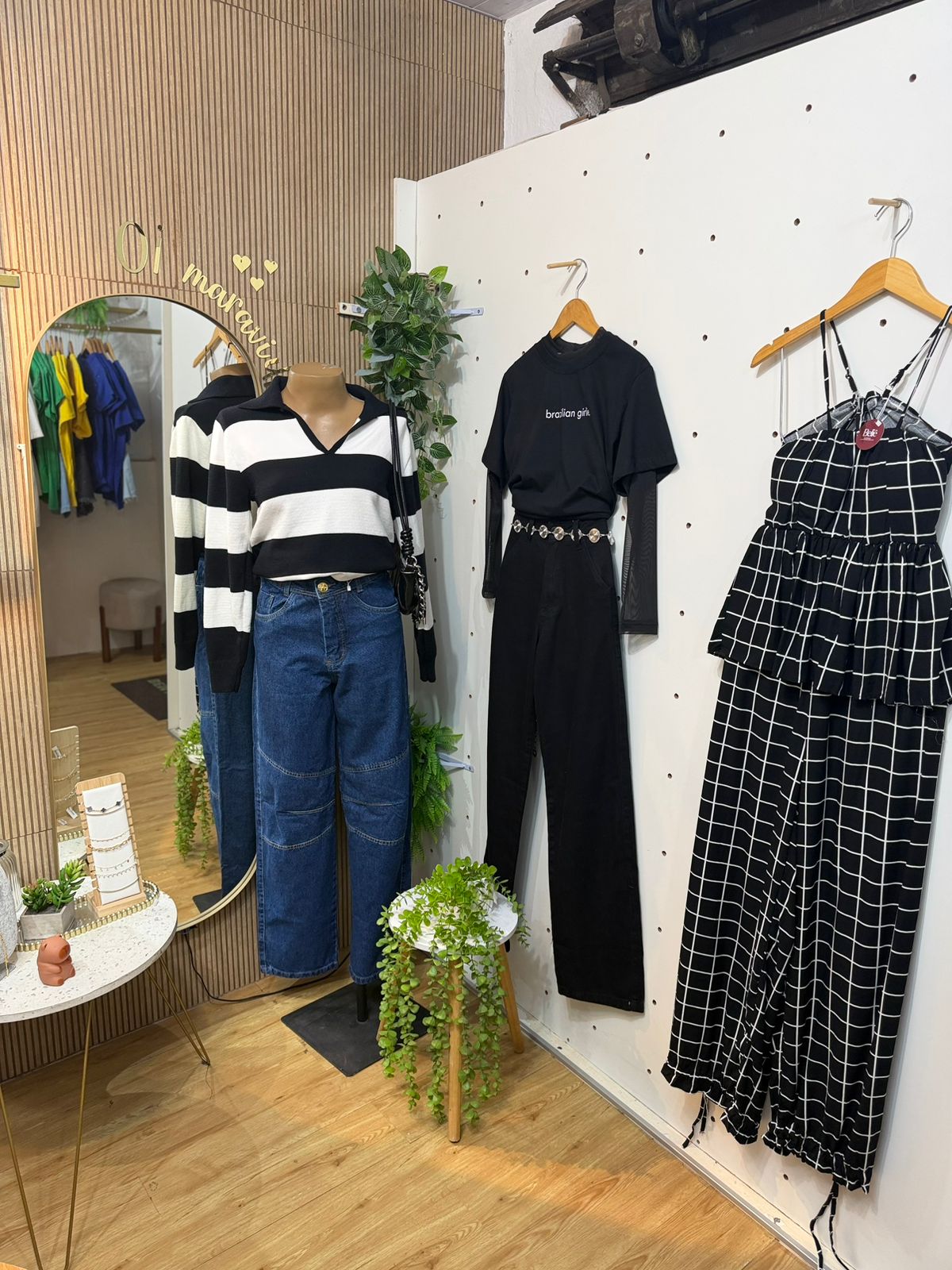 Vitrine interna com manequim, espelho e looks montados